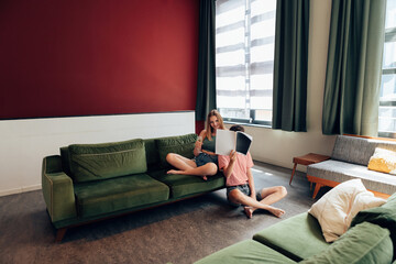 couple sitting relaxed in a big hotel room or youth hostel or home room reading magazine