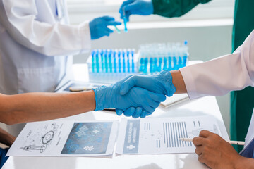 Collaboration of doctors and nurses in the team Doctors shaking hands in a white room