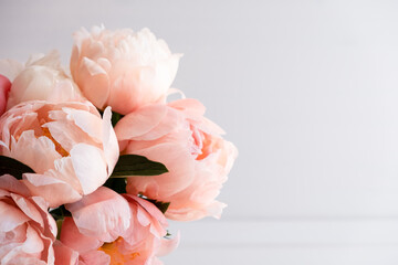Beautiful bouquet of fresh coral peony flowers in full bloom, close up. Floral still life with blooming peonies. Negative space for text.