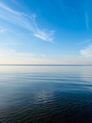 Blue sea horizon with some light clouds, seascape background
