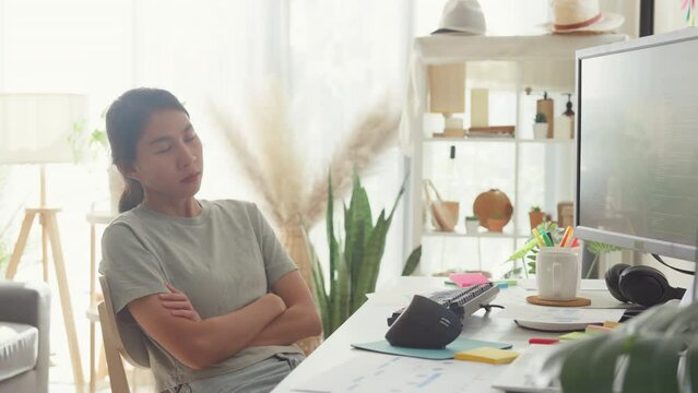Young Asia girl development programmer overwork fall asleep on her desk next to computer upload coding program database on computer at house office. Workaholic suffering mental health concept.