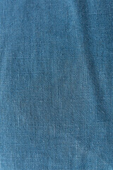 Classic blue color, vertical photo. Linen fabric blue background texture. Crumpled linen dark blue...