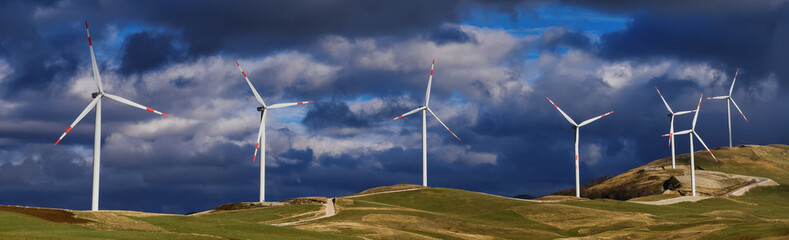 Banner format.Renewable energy. Green energy. Wind turbines on the hills in cloudy weather