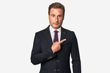 A middle-aged businessman isolated smiling and pointing aside, showing something at blank space.