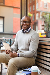 Man using tablet computer on city street