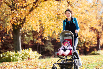 Woman running with baby stroller in park