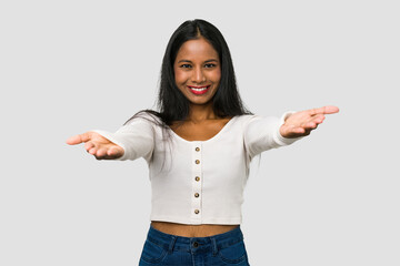 Young Indian woman cut out isolated on white background showing a welcome expression.