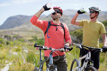 Mountain bikers driving water in rural landscape