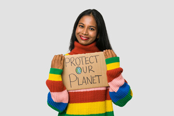 Young Indian woman holding a protect our planet placard isolated on white background