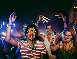 Fans with glow sticks cheering at music festival - obrazy, fototapety, plakaty