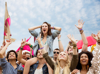 Cheering woman on top of man shoulders at music festival