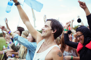 Man with water bottle cheering at music festival