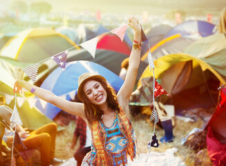 Portrait of enthusiastic woman outside tents at music festival