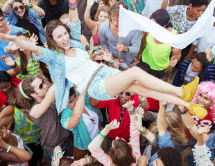 Woman crowd surfing at music festival