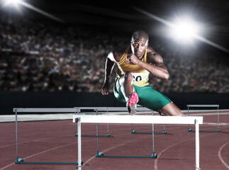 Runner clearing hurdle on track