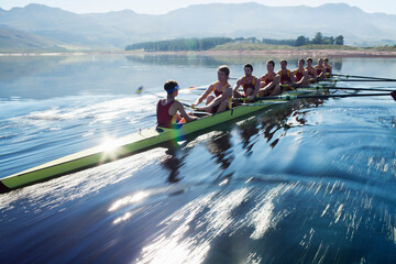 Rowing team rowing scull on lake - Powered by Adobe