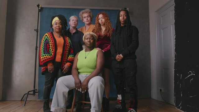 Handheld shot of six LGBTQIA queer people against studio backdrop