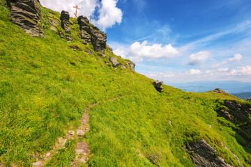 ukrainian carpathians watershed ridge adventures. terrain with stones and rocks of pikui mountan. green slopes beneath a blue sky with fluffy clouds. wonderful summer vacations on a sunny day