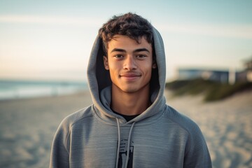 Environmental portrait photography of a satisfied boy in his 30s wearing a stylish hoodie against a beach background. With generative AI technology