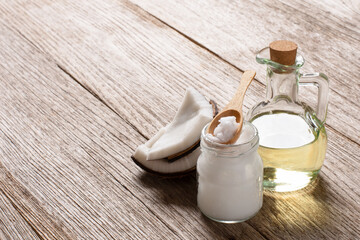 Coconut oil and brown coconut fruit on wooden table background