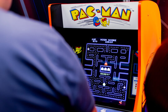 Warsaw, Poland - May 21, 2023: Man playing Pac Man arcade game