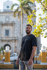 Attractive young male tourist in front of San Servacio Church in Valladolid, Mexico.