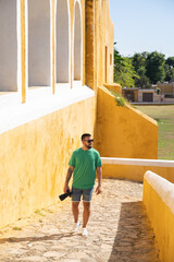 Young male tourist with camera entering the Convent of San Antonio in Izamal, Mexico.