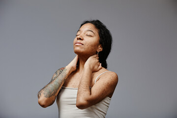 Minimal portrait of black young woman with real skin texture posing confidently with eyes closed,...