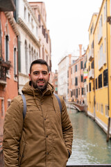 Fototapeta na wymiar Young male tourist on the canals of Venice happily