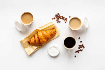 Different types of coffee in paper cup with croissant