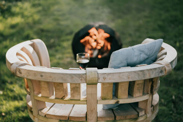 Wooden bench with wine glass and fire bucket on the grass in the garden