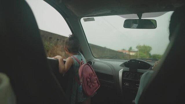 Little Girl viewing outside a window of a Moving Car in Goa, India (High-Res Footage)