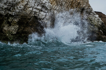 Sea waves crashing into mountain rocks