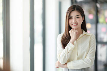 Charming Asian woman with a smile looking to the camera in the office.