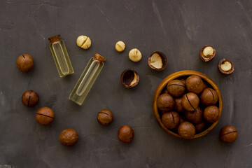 Macadamia nuts oil with raw shelled nuts, top view