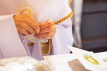 children's hands hold a rosary in a transparent bag for the first communion. Catahese