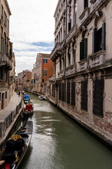 Venice canal between colorful facades and with gondolas