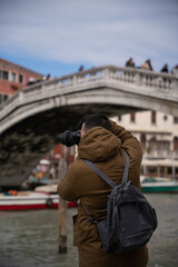 Fototapeta na wymiar young male tourist photographing the canals of venice