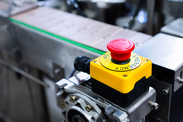 Emergency stop button for the production line at the enterprise. On the background of the production line