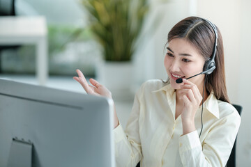 Portrait of happy smiling female customer support phone operator at workplace. Asian