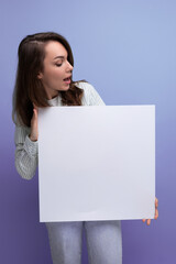 pretty brunette young business woman in a shirt demonstrates a white poster with a mockup