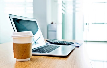 Laptop with coffee cup in office