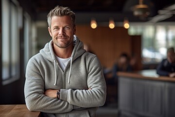 Lifestyle portrait photography of a tender mature man wearing a cozy zip-up hoodie against a spacious loft background. With generative AI technology