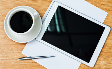 Digital tablet and a cup of coffee on the desk