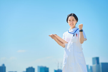 応援のポーズをする白衣の女性