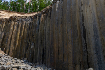 Basalt pillars in a quarry. Natural basalt rock columns closeup texture. Abstract natural...