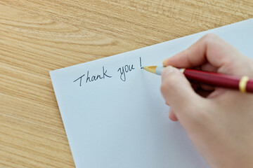 Hand writing thank you on white paper