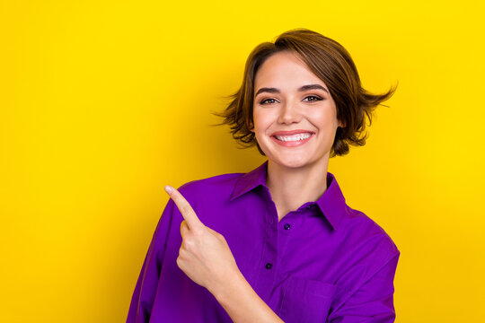 Photo of attractive promoter girl direct finger empty space novelty mockup wear elegant blouse isolated yellow color background