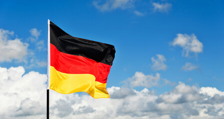 German flag waving against blue sky