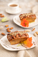 Caramel and almond cake on brown concrete, side view, selective focus